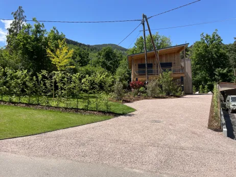 Aménagement d'un chalet avec accès en stabilisé maintenu en périphérie par les lisses métalliques + végétalisation de l'ensemble du jardin
