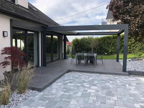 Terrasse en grès céramique avec périphérie en marche blocs béton grenaillé et pergolas