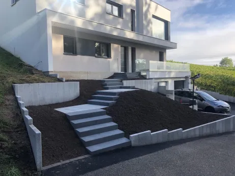Escalier avec marches blocs béton grenaillé, paliers intermédiaires en dalles + palissades de retenue en Granit 